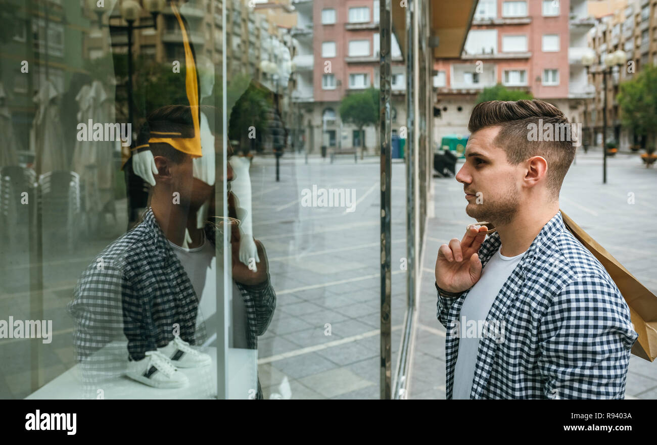 Uomo che guarda la vetrina di un negozio Foto Stock