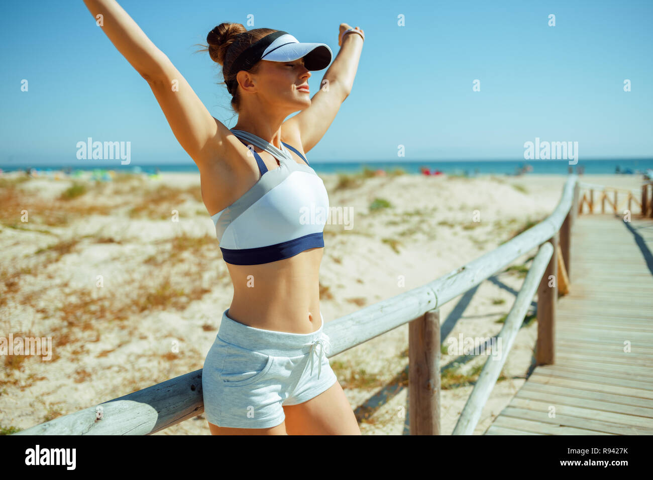 Donna sana pareggiatore fitness in vestiti sulla costa dell'oceano esultanza. È sempre bello avere le cose fatte. 30 qualcosa di anni vecchia donna imprenditore Foto Stock