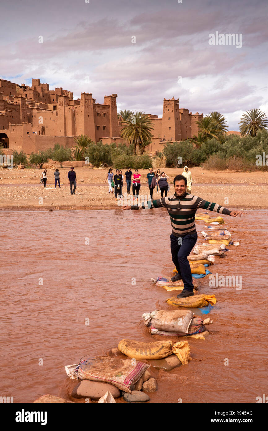 Il Marocco, Ouarzazate, Ksar di Ait-Ben-Haddou, Kasbah, uomo utilizzando Ounila fiume pietre miliari Foto Stock