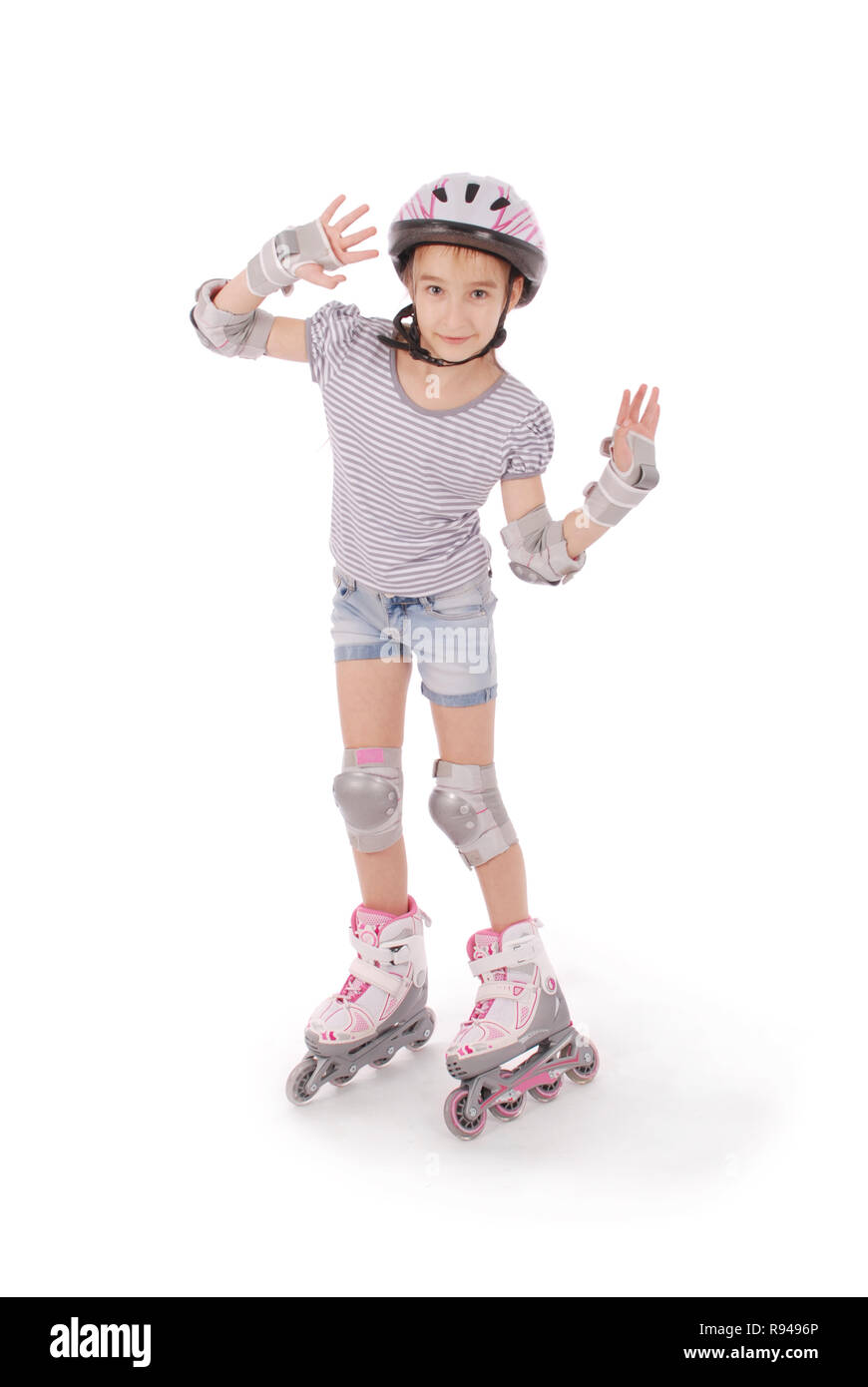 Poco Pretty girl su pattini a rotelle contro uno sfondo bianco Foto Stock
