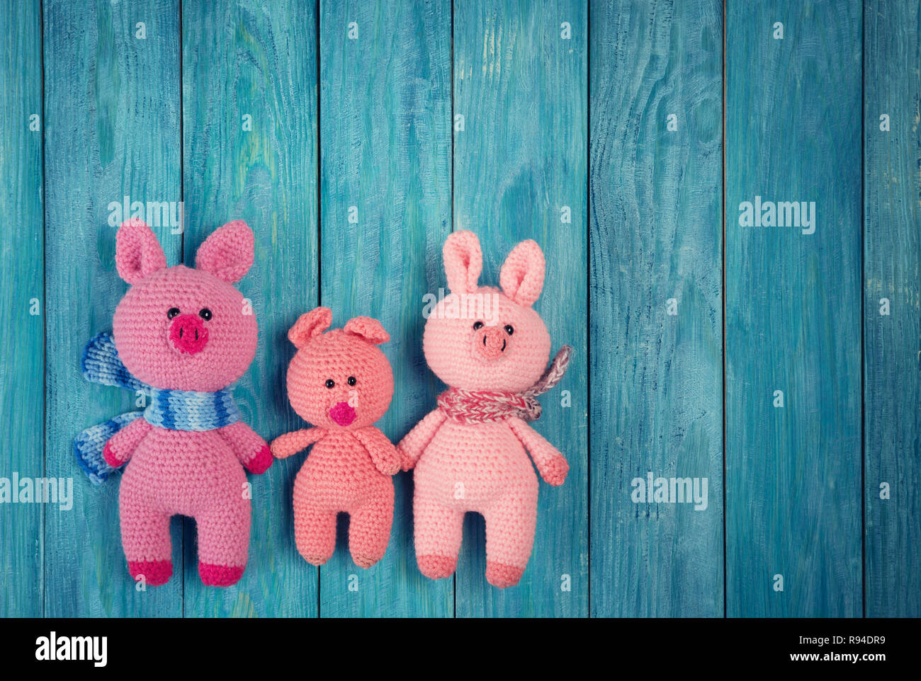 Maialino famiglia blu su sfondo di legno Foto Stock