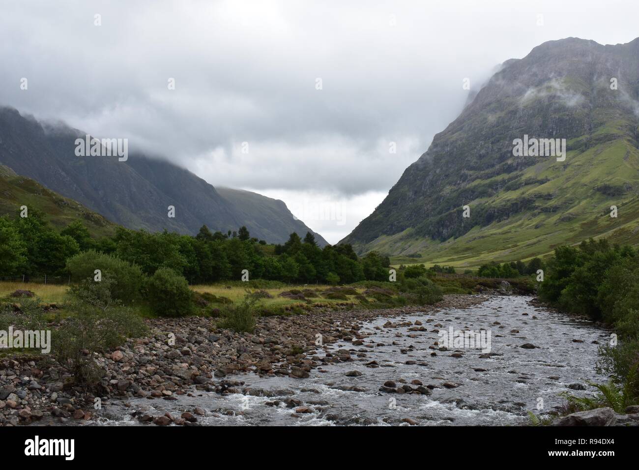 Il COE del fiume che scorre attraverso la valle di Glencoe Mountain Range nelle Highlands Scozzesi. Prese a piovere e Nuvoloso Giorno di agosto. Foto Stock