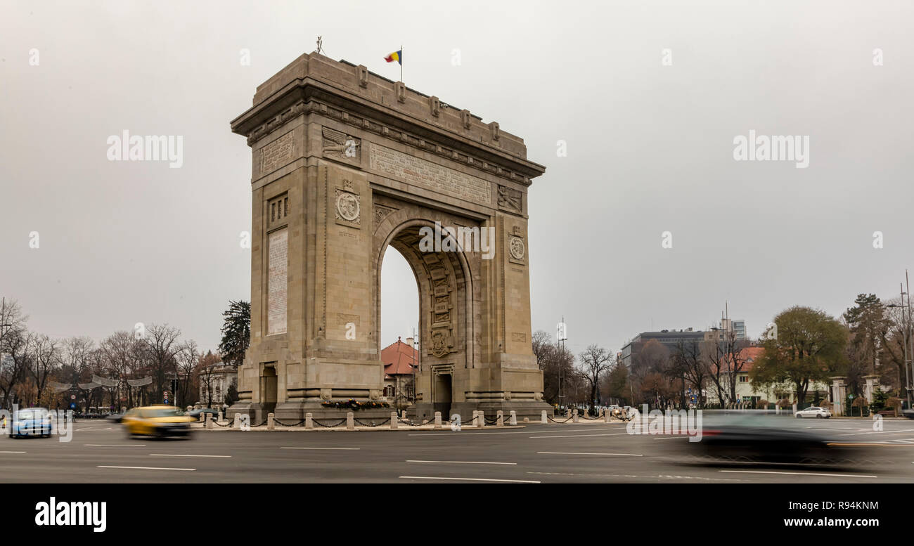 Bucarest, Romania - 7 dicembre: veicoli che passano dal Arcul de Triumf (l'Arco di Trionfo) il 7 dicembre 2018 a Bucarest, in Romania. L'Arco di Trionfo è stato costruito nel 1922 per la memoria di vincere la guerra di parola I. Foto Stock