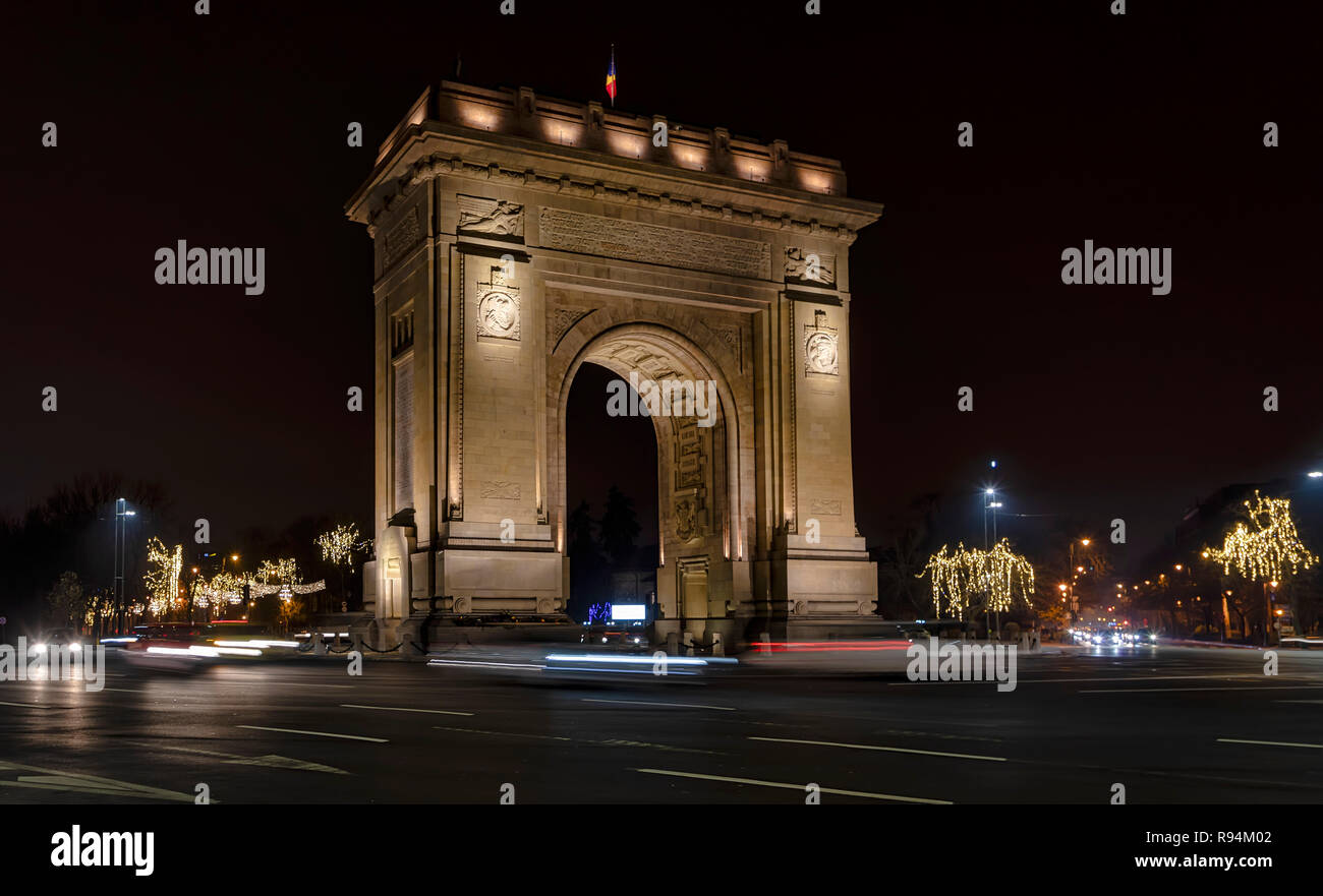 Bucarest, Romania - 9 dicembre: veicoli che passano dal Arcul de Triumf (l'Arco di Trionfo) il 9 dicembre 2018 a Bucarest, in Romania. L'Arco di Trionfo è stato costruito nel 1922 per la memoria di vincere la guerra di parola I. Foto Stock