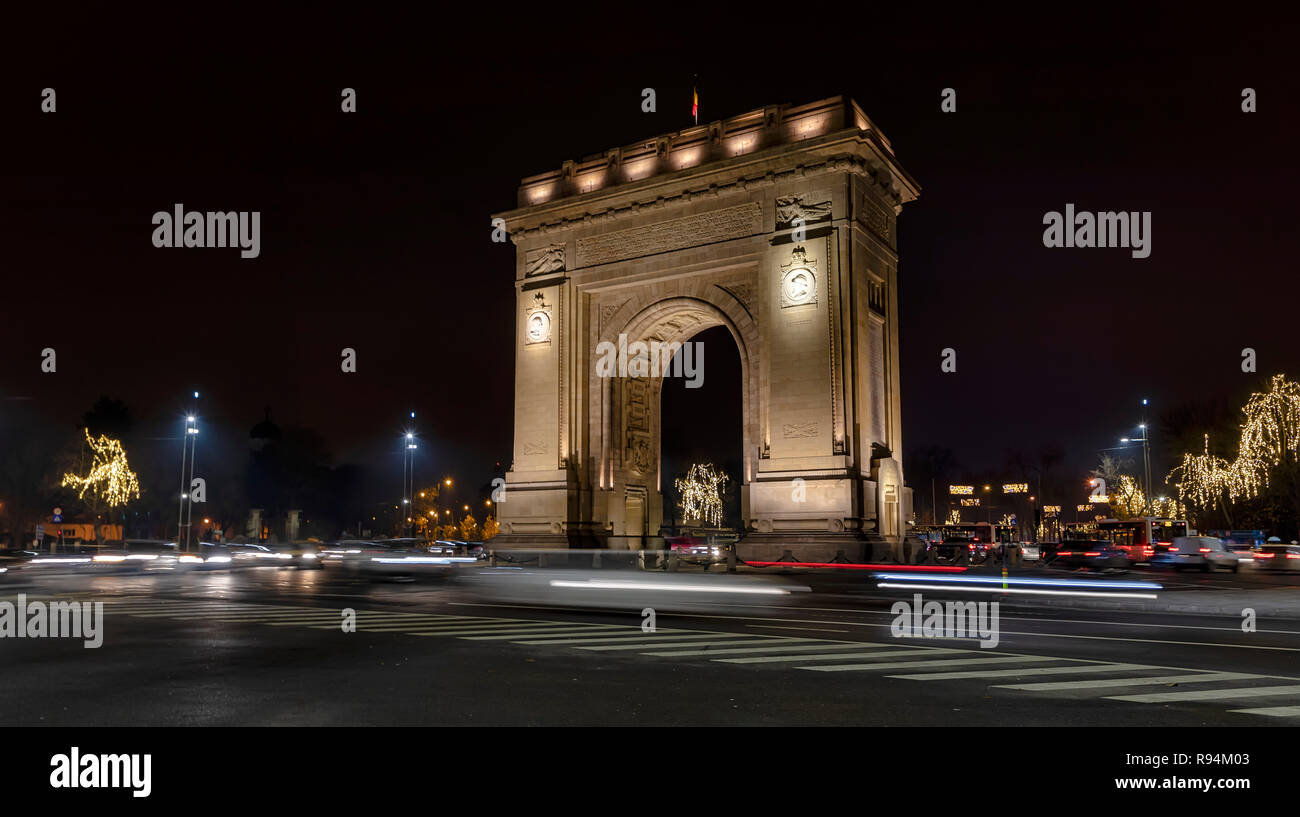 Bucarest, Romania - 9 dicembre: veicoli che passano dal Arcul de Triumf (l'Arco di Trionfo) il 9 dicembre 2018 a Bucarest, in Romania. L'Arco di Trionfo è stato costruito nel 1922 per la memoria di vincere la guerra di parola I. Foto Stock