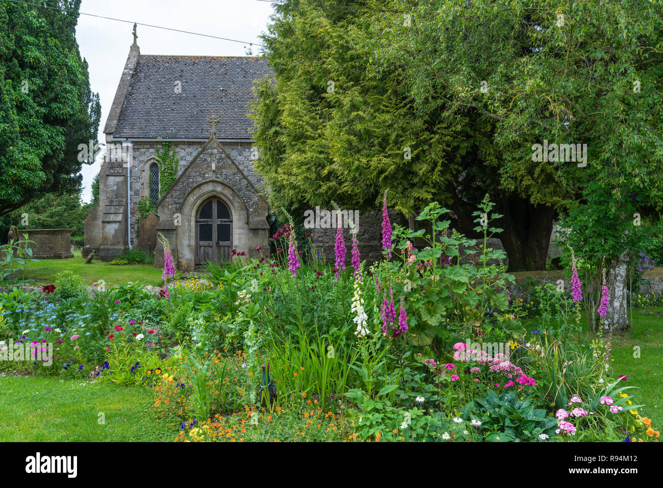 Un piccolo giardino fiorito e la porta della chiesa a Salisbury, Wiltshire, Inghilterra, l'Europa. Foto Stock