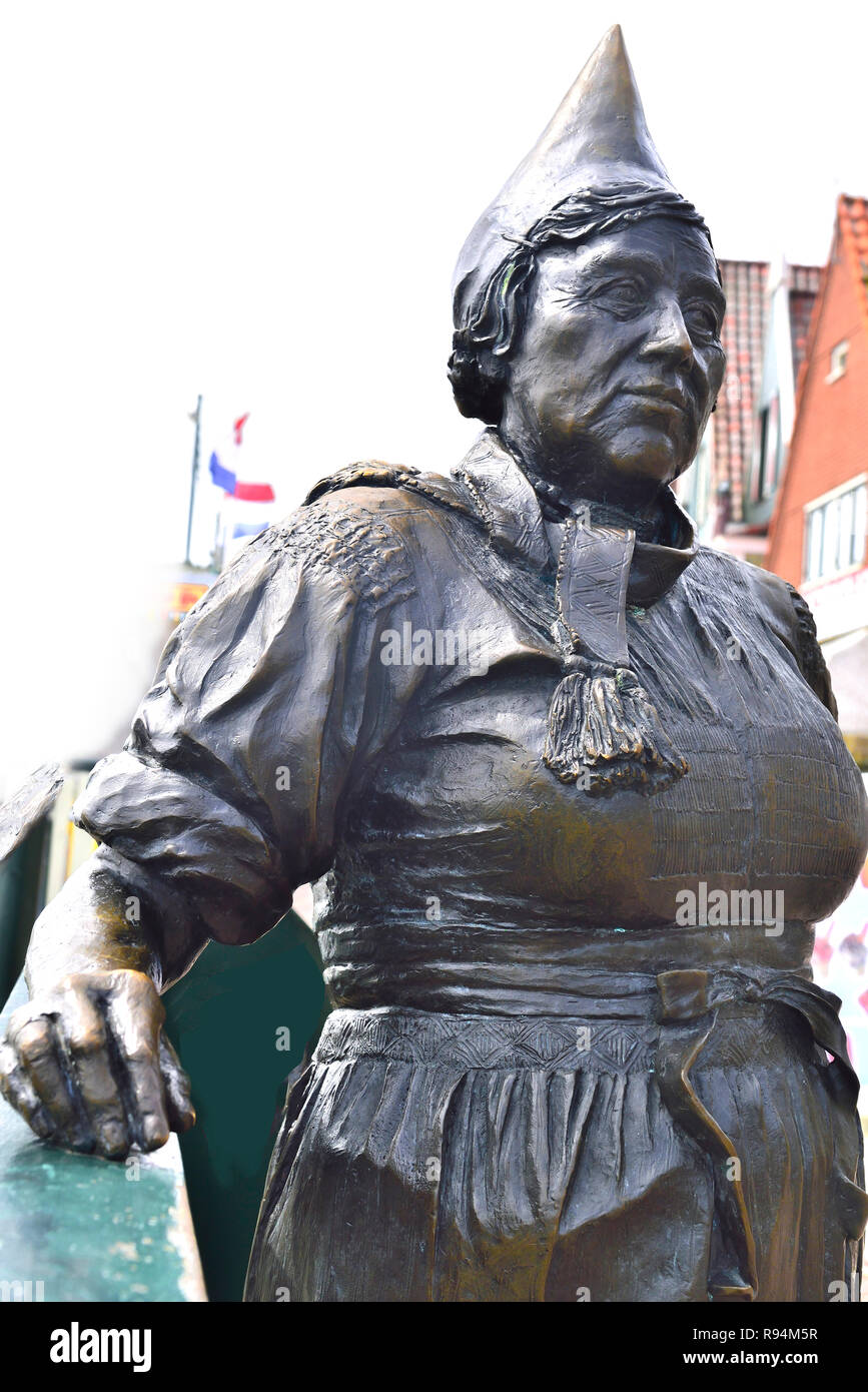 Parte di una statua di bronzo di un fisherwoman nel vecchio porto di pescatori di Volendam, North Holland, Paesi Bassi Foto Stock