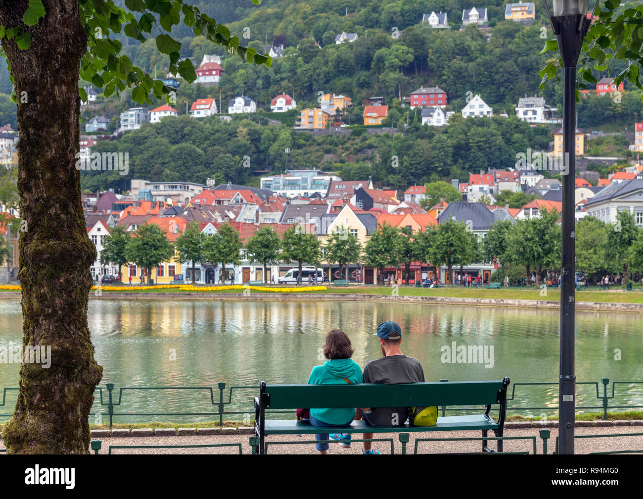 Coppia seduta su una panchina a Lille Lungegårdsvannet, un parco e lago nel centro della città, Bergen, Norvegia Foto Stock
