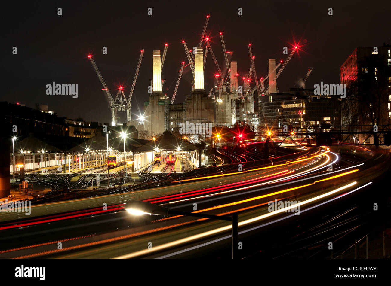 Battersea Power Station di notte con gru e treni. Visto dalla stazione ferroviaria di Victoria. Apple Campus. Foto Stock