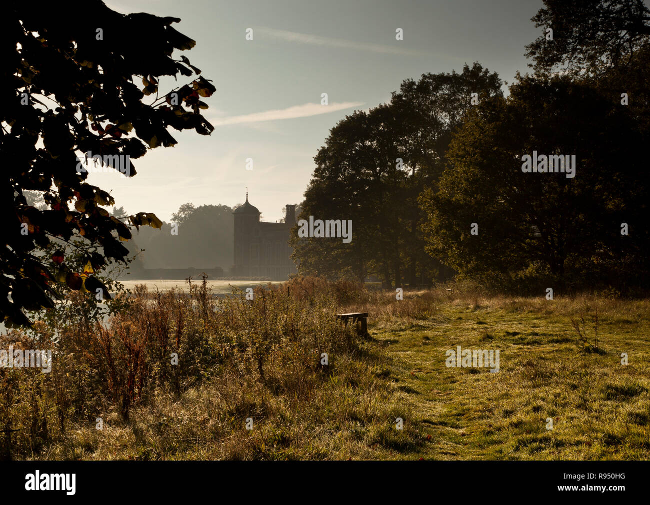 Silhouette di Blickling Hall, Norfolk, Regno Unito, con nebbia atmosferica passando sopra il lago Foto Stock