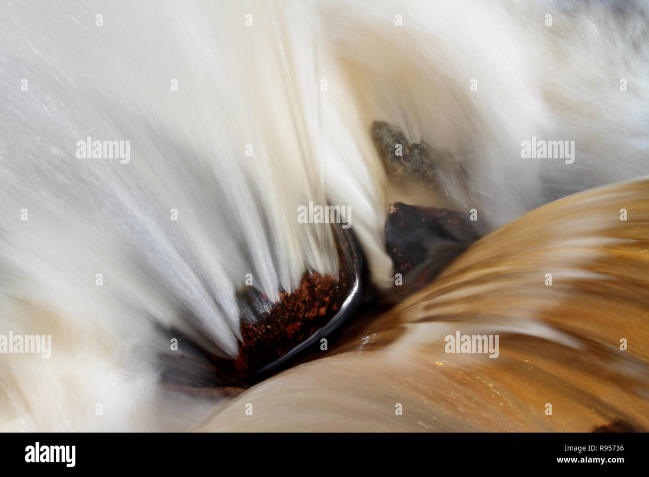 L'acqua sta fluendo hard in acqua bianca rapids. Una pietra di granito in mezzo agli spruzzi d'acqua. Foto Stock