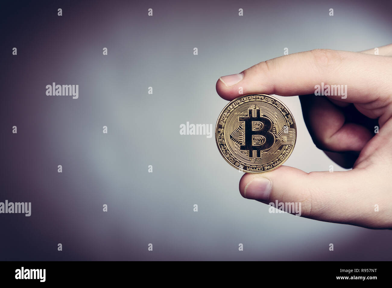 Bitcoin cryptocurrency moneta in oro in mano d'uomo Foto Stock