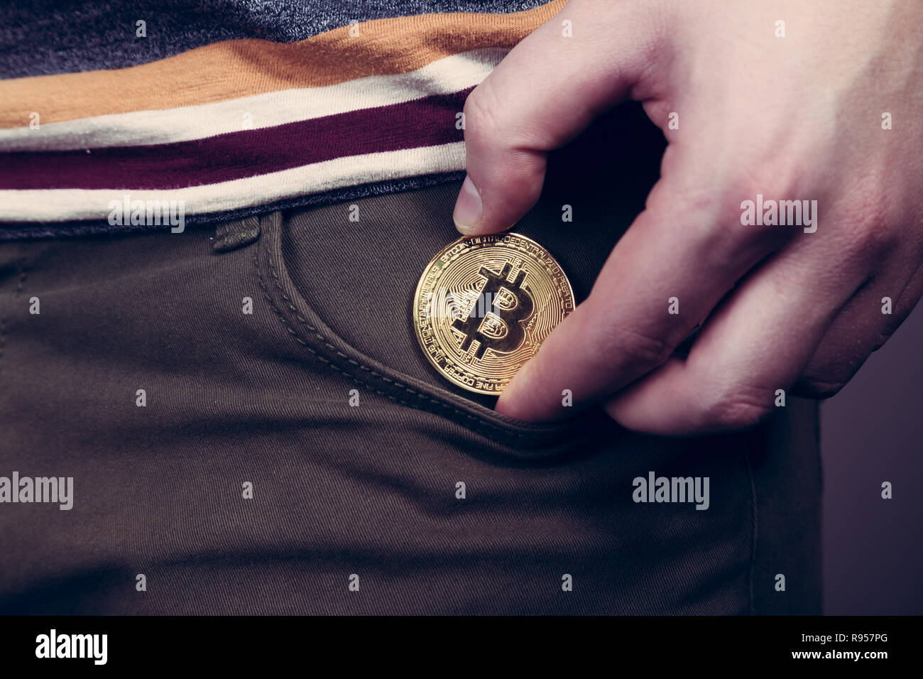 Mettere bitcoin cryptocurrency moneta nella tasca Foto Stock