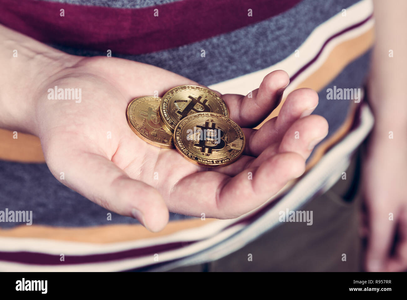 L uomo è mantenere bitcoin cryptocurency moneta in oro in mano Foto Stock