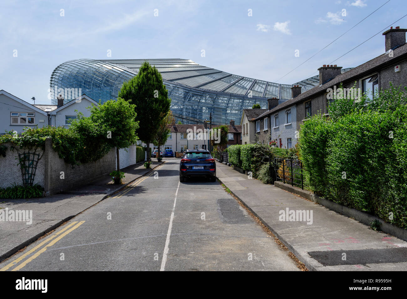 Street in un quartiere con case con enormi Aviva Stadium in background, Dublino, Irlanda Foto Stock