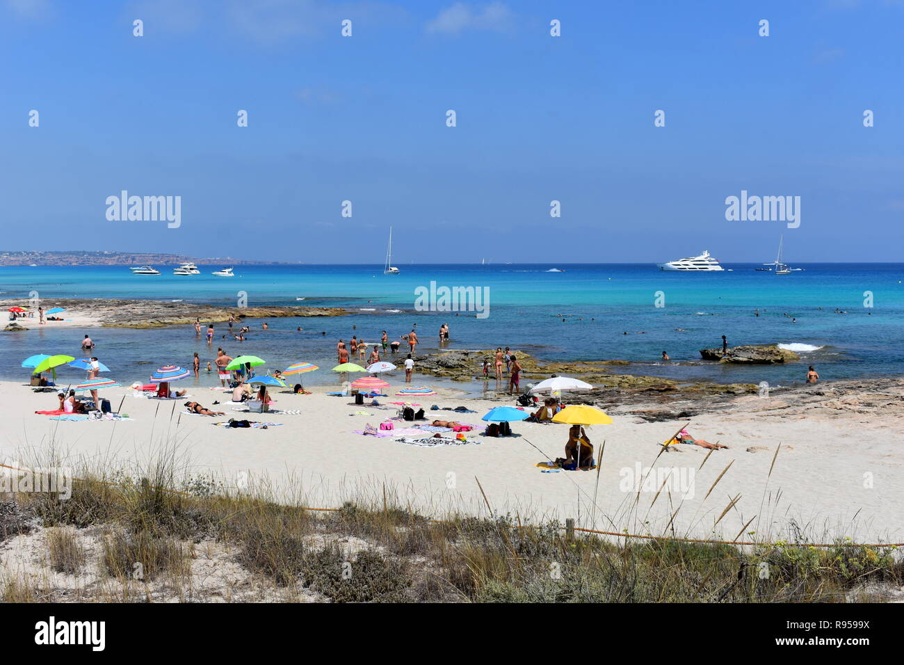 Barche ancorate fuori dalla trafficata Es Calo beach, Formentera, Spagna Foto Stock