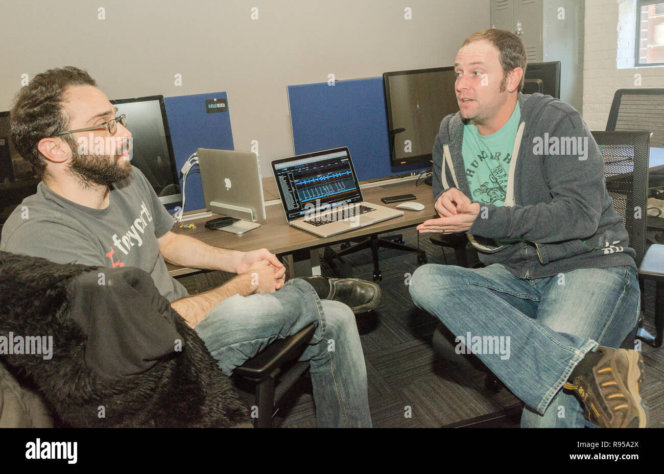 Adam Reeves e Jamie Bailey discutere dei prezzi degli scenari per la loro azienda, stato iniziale, al Nashville imprenditore centro di Nashville, Tennessee. Foto Stock