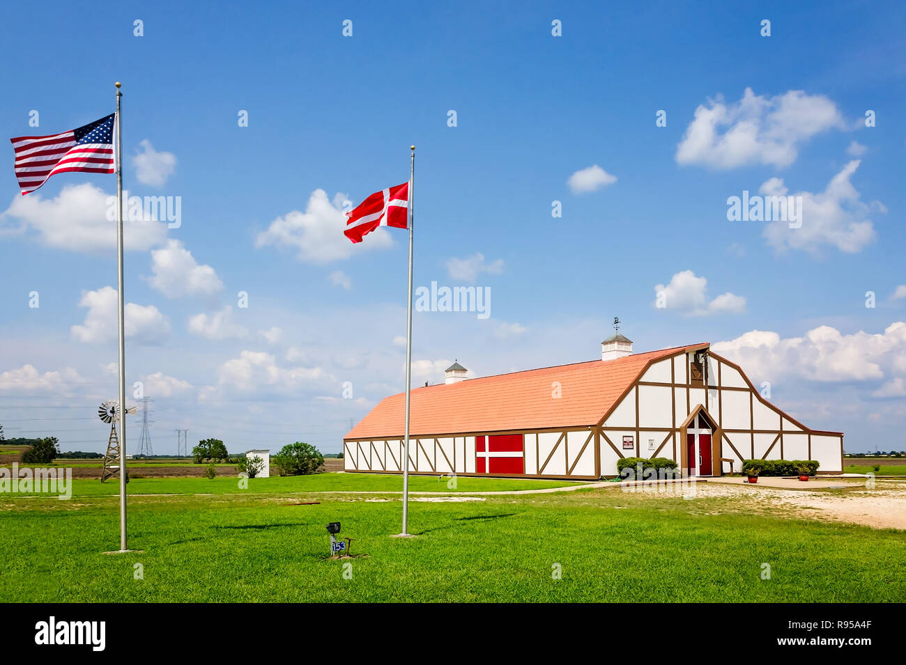 Gli Stati Uniti bandiera e la bandiera della Danimarca volare al di fuori il danese Heritage Museum, Sett. 3, 2017, in Danevang, Texas. Foto Stock