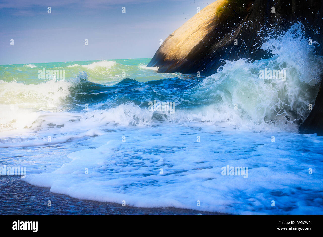 Questa unica foto mostra come il mare surf sulla spiaggia urta contro una roccia. La foto è stata scattata in Hua Hin Tailandia Foto Stock