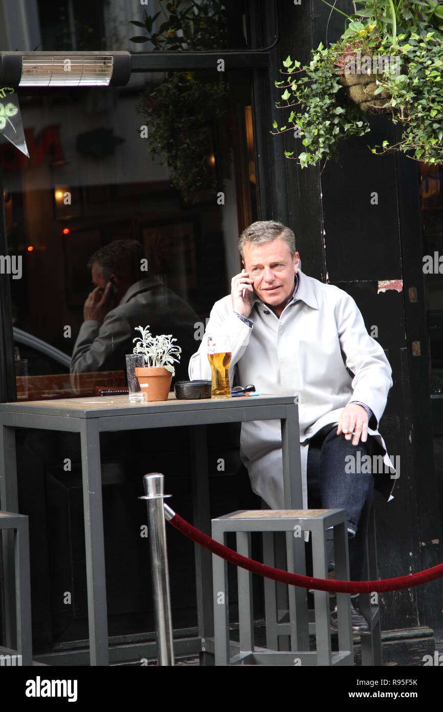 Madness Ska e gruppo pop cantante e song writer Graham McPherson noto con il nome di fase Suggs mostrato avente una birra a Londra il 18 marzo 2014. Musicista. Presentatore radio. Attore. Suggs. La follia di banda. Genere Ska. Foto Stock