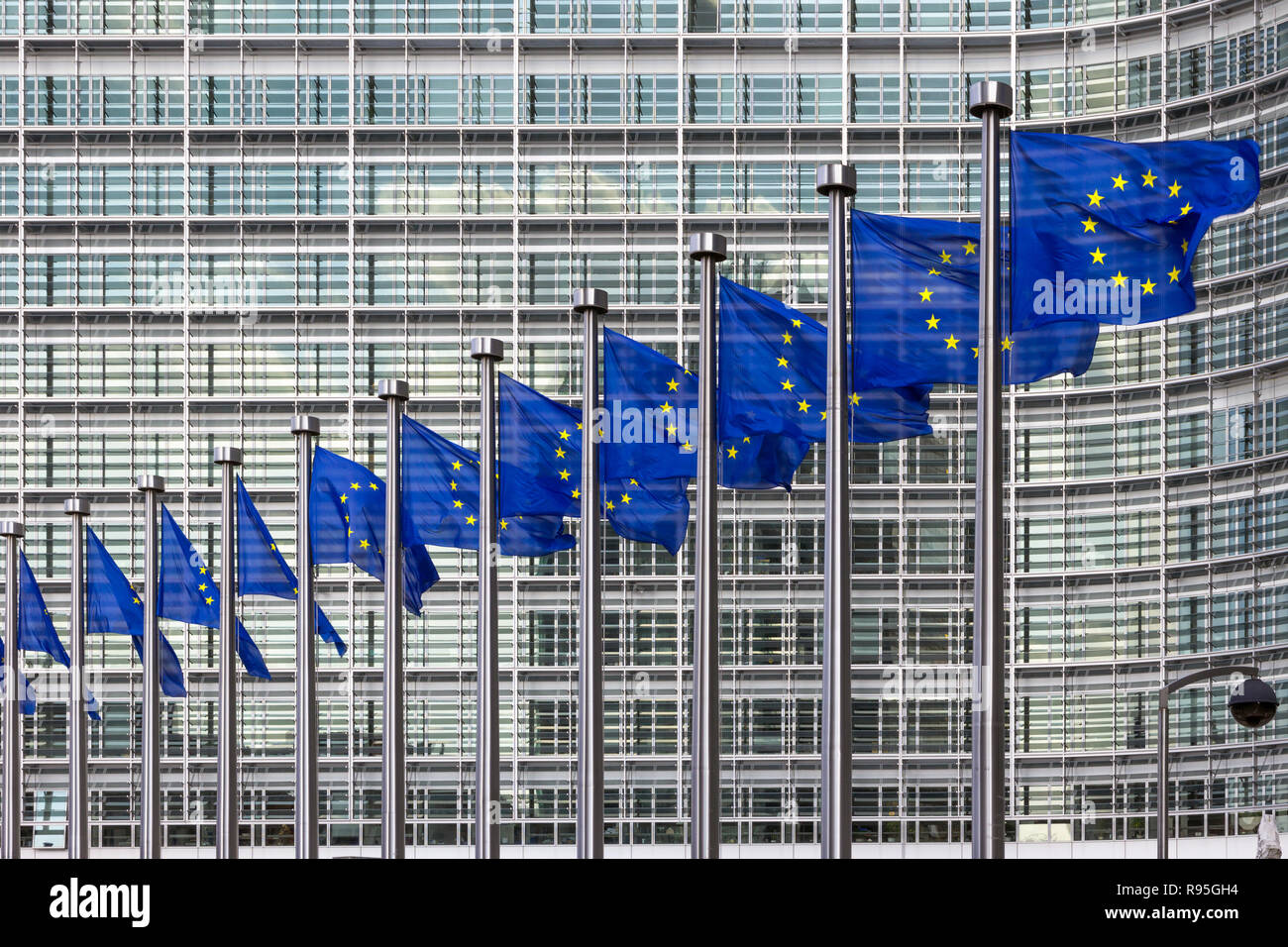 Fila di bandiere dell'UE di fronte all'Unione europea edificio della Commissione a Bruxelles Foto Stock