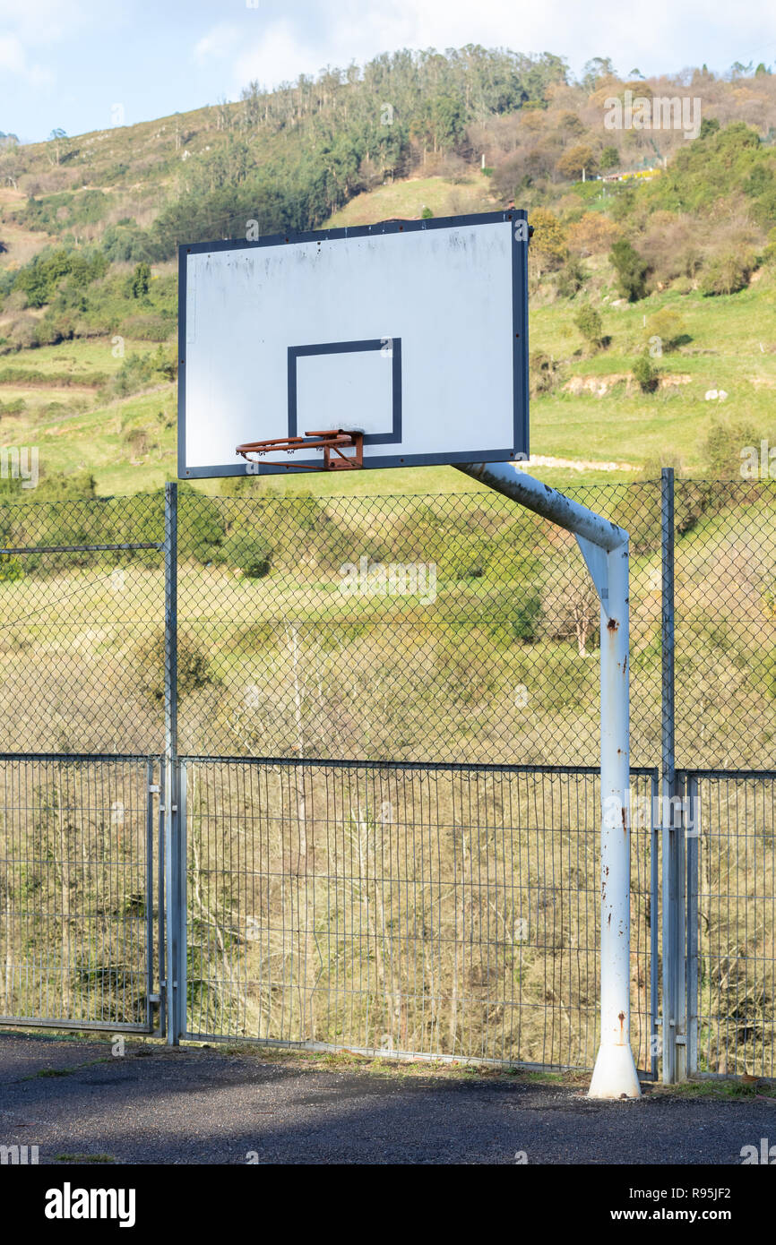 Old street basketball anello contro il cielo e di foreste di montagna Foto Stock