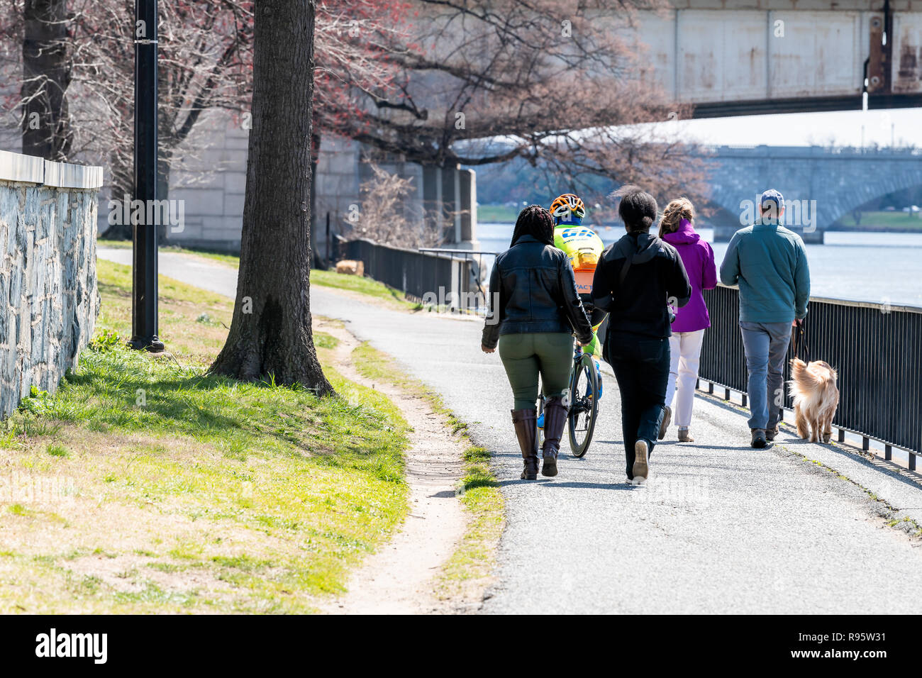 Washington DC, Stati Uniti d'America - Aprile 5, 2018: persone, turisti passeggiate con il cane, equitazione Bicicletta bici sul sentiero lastricato sentiero, molla lungo Rock Creek Park Potomac Foto Stock