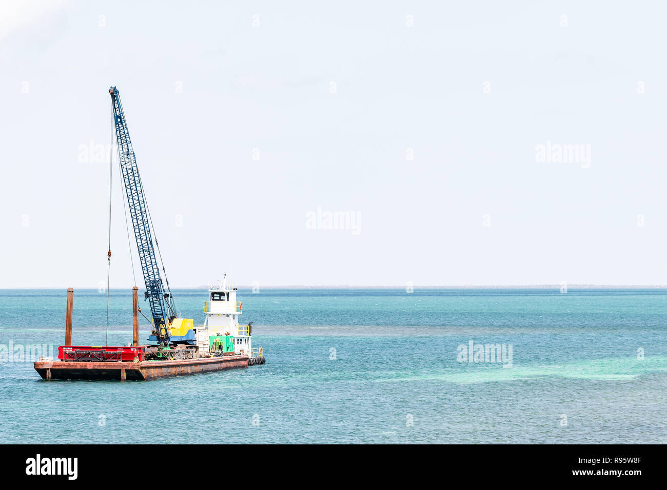 Tasto Piegon, Stati Uniti d'America - 1 Maggio 2018: Costruzioni navali, nave in oceano, acqua di mare con gru eseguendo riparazioni, isola di edificio dopo l uragano Irma a F Foto Stock