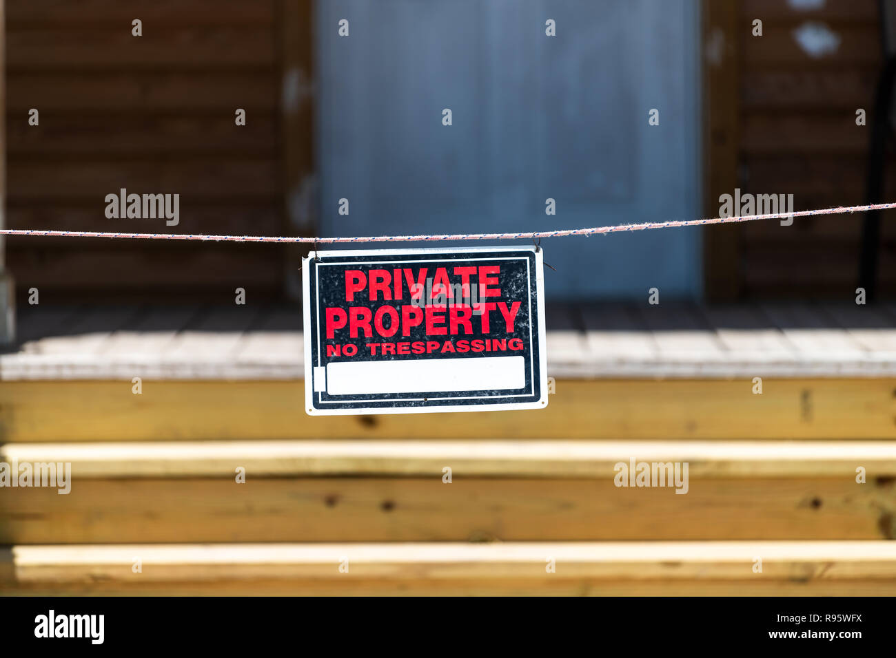 La proprietà privata senza sconfinamenti di segno appeso sulla corda, il filo esterno, all'aperto su via da casa, home edificio con ingresso, passaggi, scale, scale Foto Stock