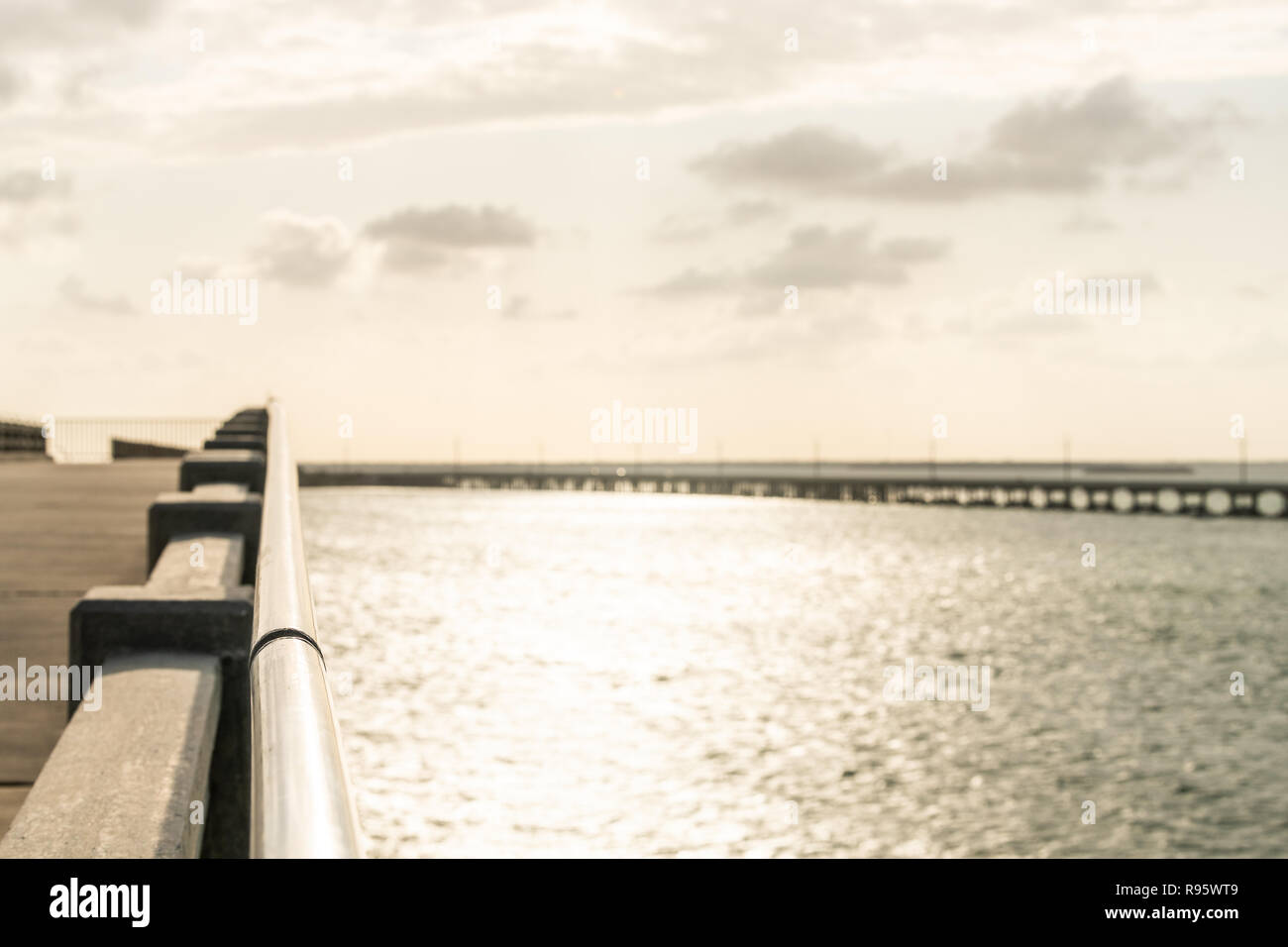 Sulla parte superiore del vecchio derelitti, abbandonati di Bahia Honda Rail bridge con vista sulla Overseas Highway road al tramonto, nuvole oceano, acqua di mare, golden orange yello Foto Stock