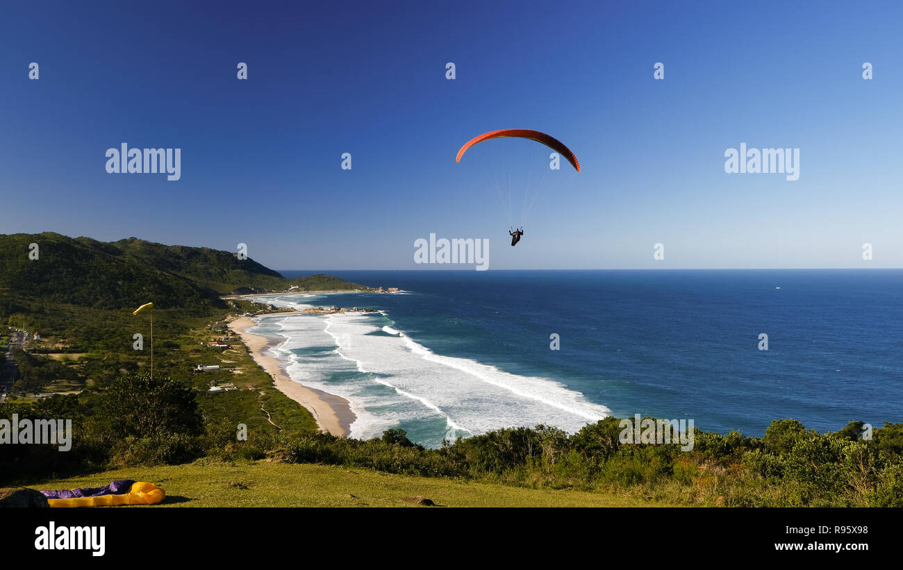 Paraglinding dalla collina di Mole spiaggia sul mare e le montagne. Florianópolis, stato di Santa Catarina, Sud America, Brasile. Foto Stock