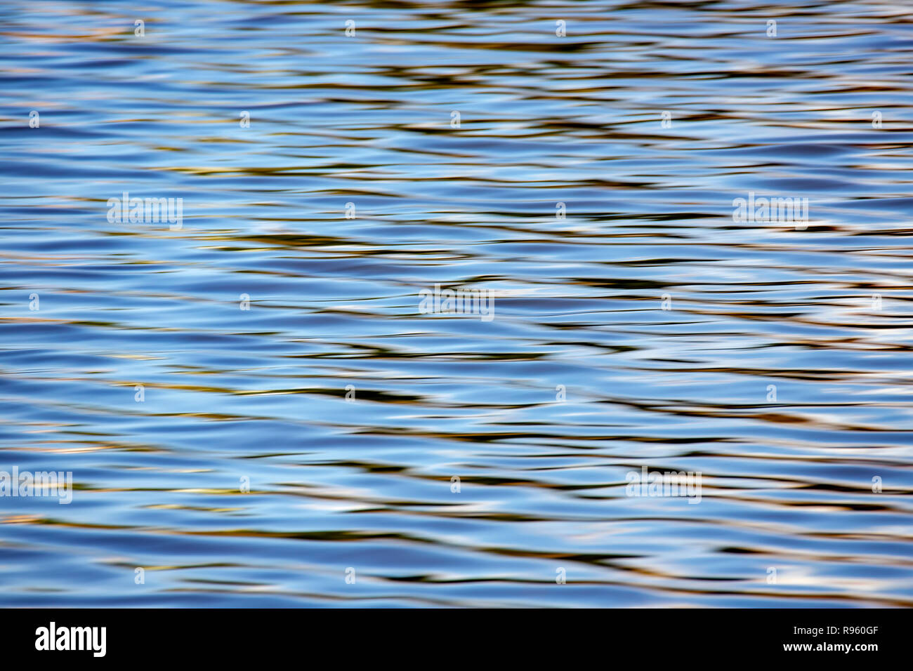 Abstract della superficie dell'acqua sfondo con increspature e sun la riflessione su di essa Foto Stock