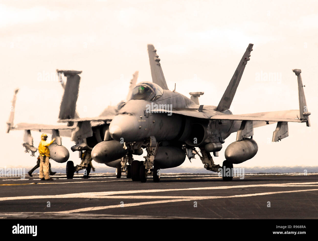 Un ponte di volo guide direttore un F/A-18C Hornet attaccato al Argonauts di Strike Fighter Squadron uno quattro sette (VFA- 147) sul ponte di volo dell'Nimitz-class portaerei USS John C. Stennis (CVN 74). Stati Uniti Foto di Marina di Massa lo specialista di comunicazione di terza classe Jon Hyde Foto Stock