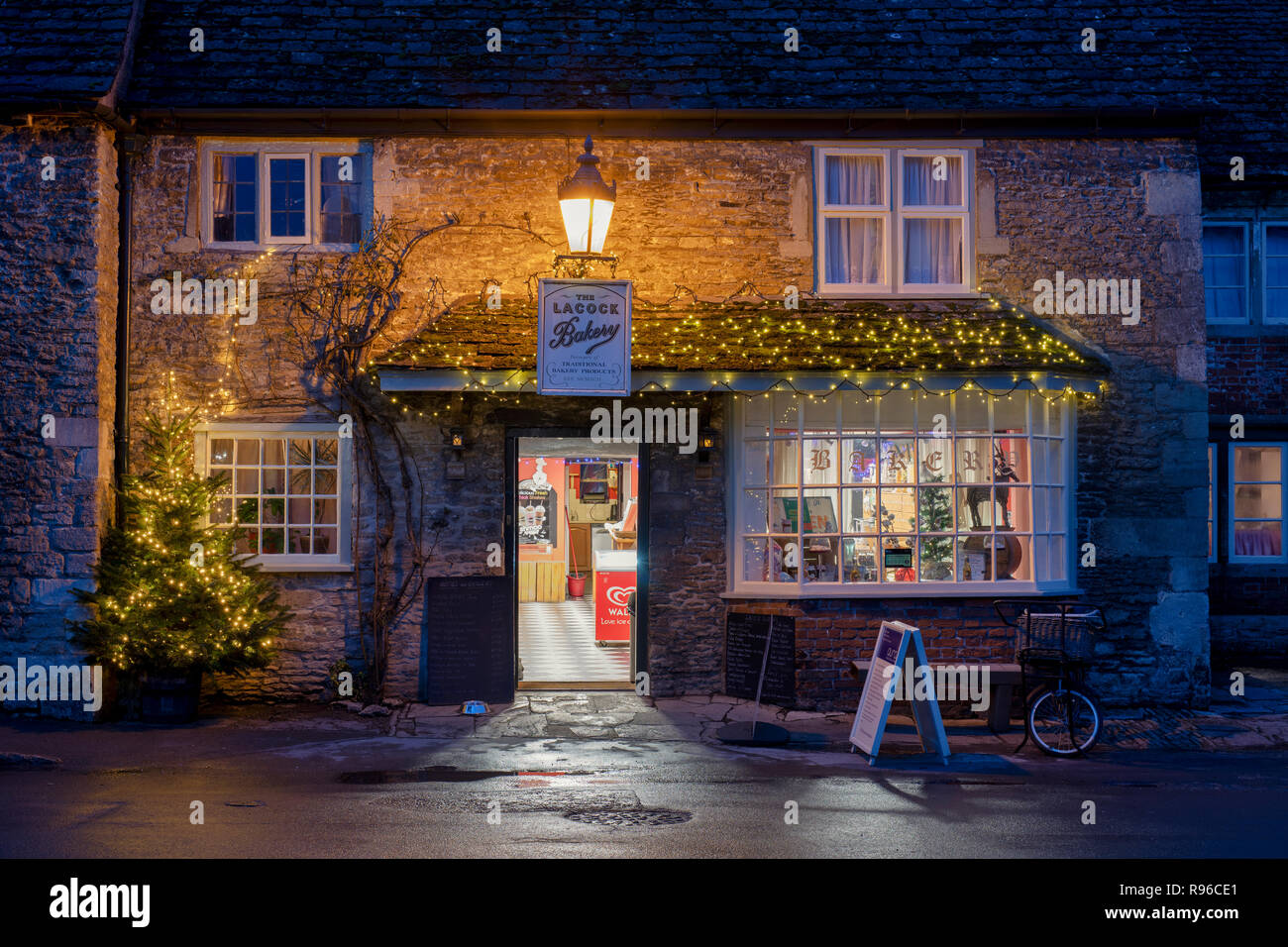 Lacock forno del paese di notte con un albero di natale e decorazioni. Lacock, Cotswolds, Wiltshire, Inghilterra Foto Stock