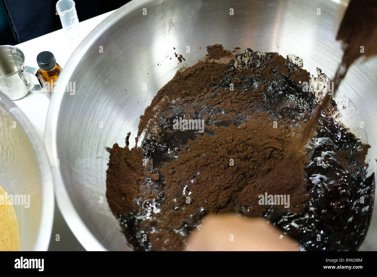 La miscelazione di ingredienti per la produzione di caffè macinato scrub corpo crema. in casa bellezza dermocosmesi prodotto cosmetico Foto Stock