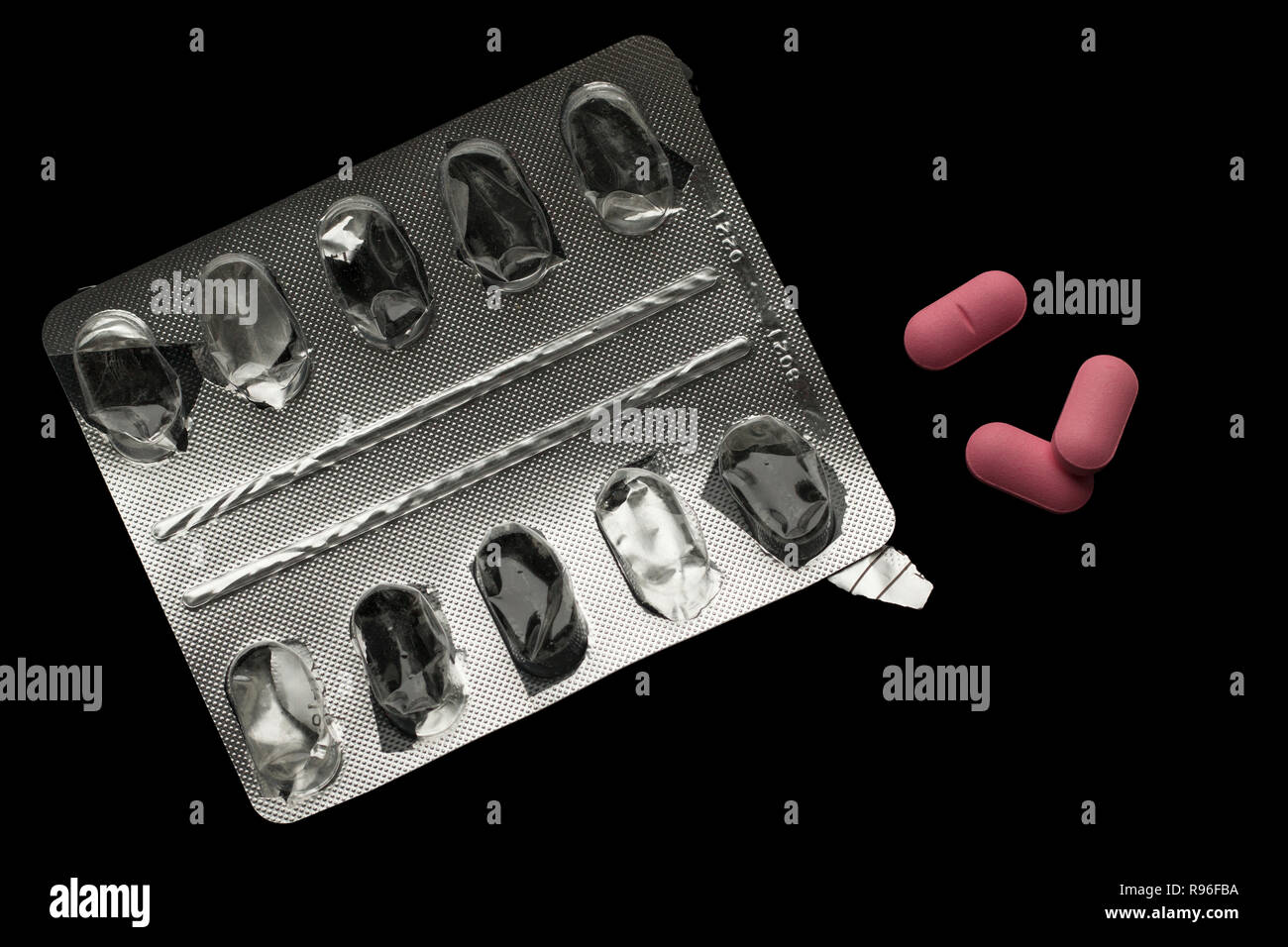 Svuotare blister e tre pillole rosa isolati su nero. Vista superiore Foto Stock