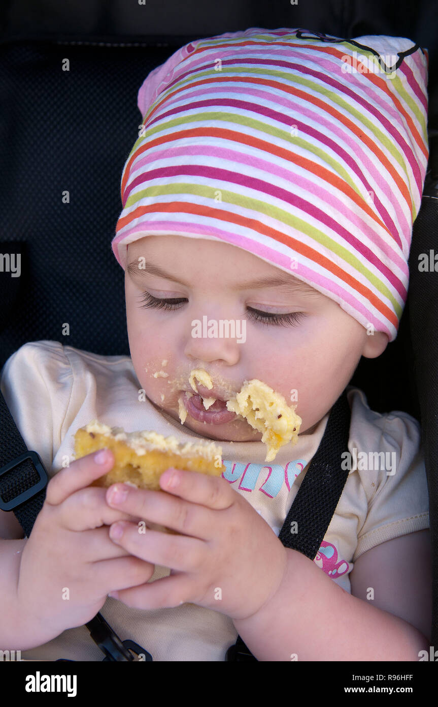 BW8DBF todler godendo di mangiare una torta e facendo un pasticcio Foto Stock