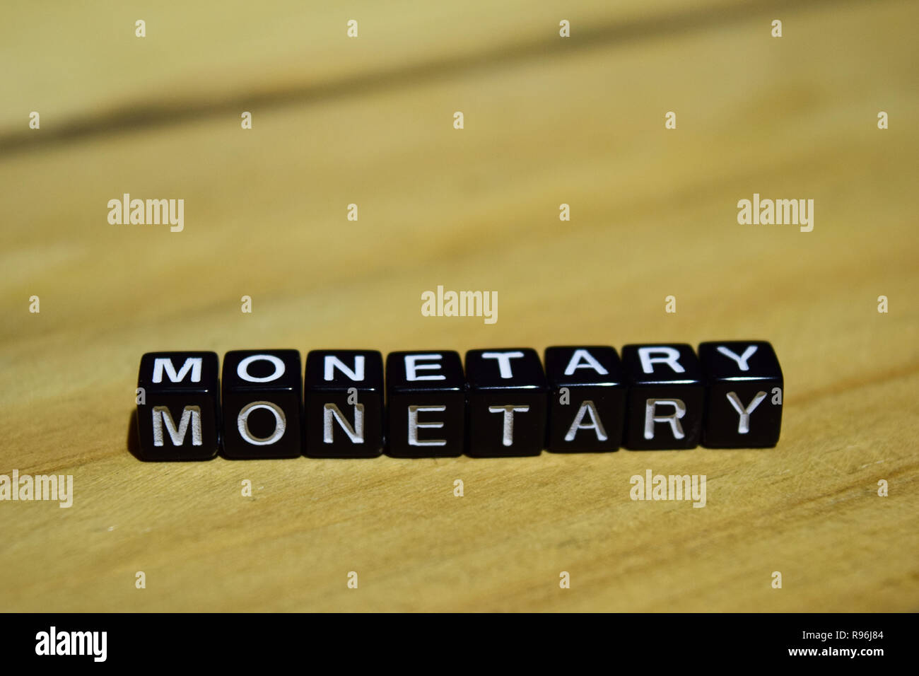 Scritto monetaria su blocchi di legno. Ispirazione e motivazione concetti. Croce immagine elaborata su sfondo di legno Foto Stock