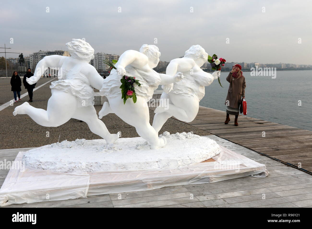 Salonicco, Grecia, 20 dicembre 2018. Una donna prende una fotografia di una statua da artista cinese Xu Hongfei nel nord del porto greco città di Salonicco. Quindici statue realizzate da Xu Hongfei sono esposti presso il lungomare di Salonicco tra dicembre 17 e dicembre 24, 2018 come parte dell'artista in tutto il mondo esposizione di scultura, che inizia a Salonicco. Credito : Orhan Tsolak / Alamy Live News Foto Stock