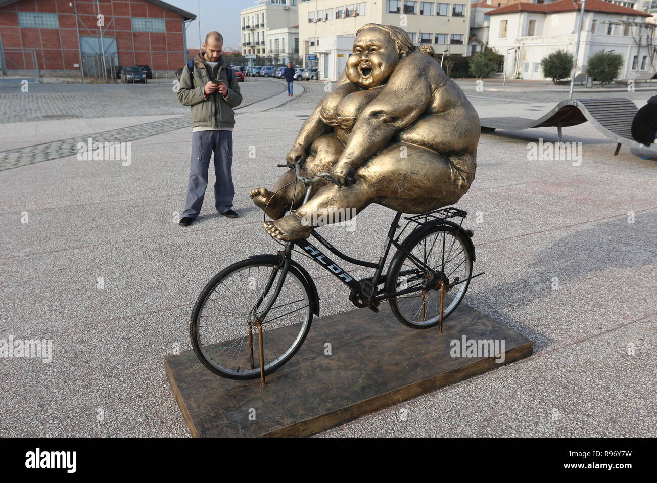 Salonicco, Grecia, 20 dicembre 2018. Un uomo sorge accanto alla statua di artista cinese Xu Hongfei nel nord del porto greco città di Salonicco. Quindici statue realizzate da Xu Hongfei sono esposti presso il lungomare di Salonicco tra dicembre 17 e dicembre 24, 2018 come parte dell'artista in tutto il mondo esposizione di scultura, che inizia a Salonicco. Credito : Orhan Tsolak / Alamy Live News Foto Stock