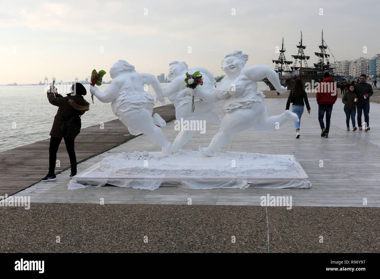 Salonicco, Grecia, 20 dicembre 2018. Una donna prende un selfie accanto alla statua da artista cinese Xu Hongfei nel nord del porto greco città di Salonicco. Quindici statue realizzate da Xu Hongfei sono esposti presso il lungomare di Salonicco tra dicembre 17 e dicembre 24, 2018 come parte dell'artista in tutto il mondo esposizione di scultura, che inizia a Salonicco. Credito : Orhan Tsolak / Alamy Live News Foto Stock