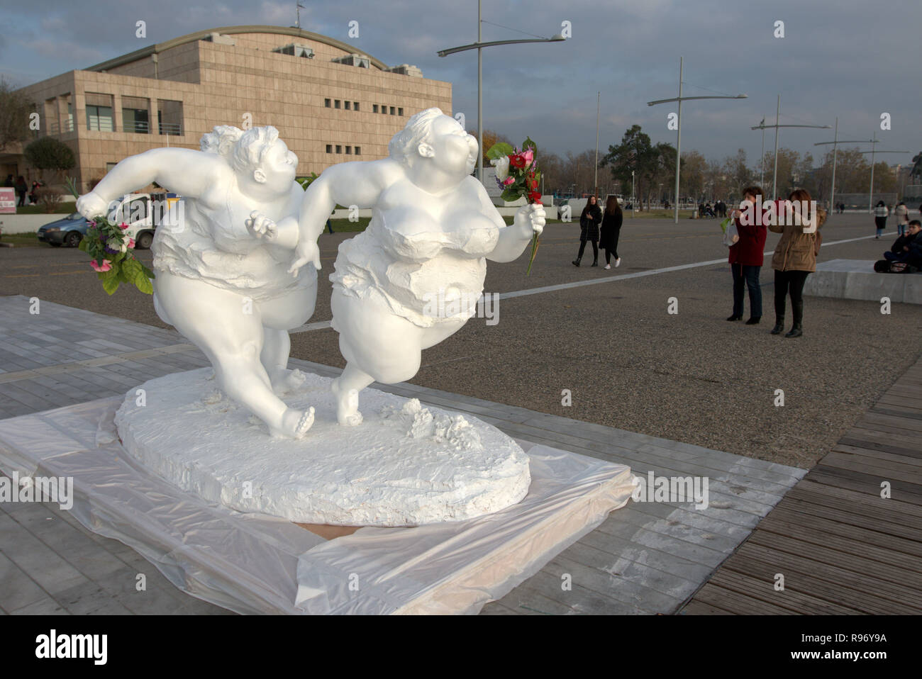 Salonicco, Grecia, 20 dicembre 2018. Due donne di scattare fotografie di una statua di artista cinese Xu Hongfei nel nord del porto greco città di Salonicco. Quindici statue realizzate da Xu Hongfei sono esposti presso il lungomare di Salonicco tra dicembre 17 e dicembre 24, 2018 come parte dell'artista in tutto il mondo esposizione di scultura, che inizia a Salonicco. Credito : Orhan Tsolak / Alamy Live News Foto Stock