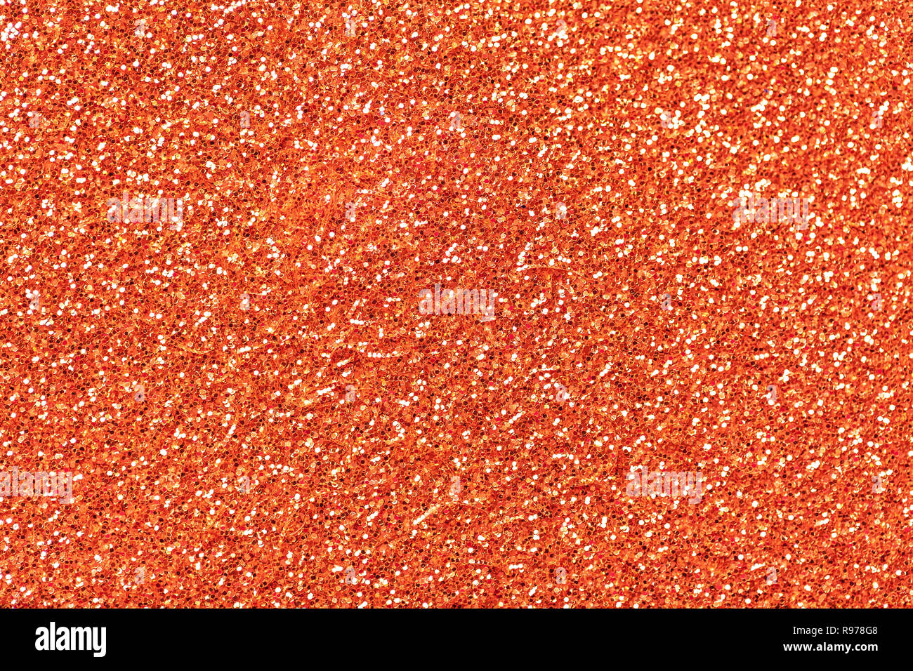 Arancio brillante background spumante da piccole paillettes, primo piano. Brillante sfondo lucido dal tessile. Luccichio carta di corallo Foto Stock