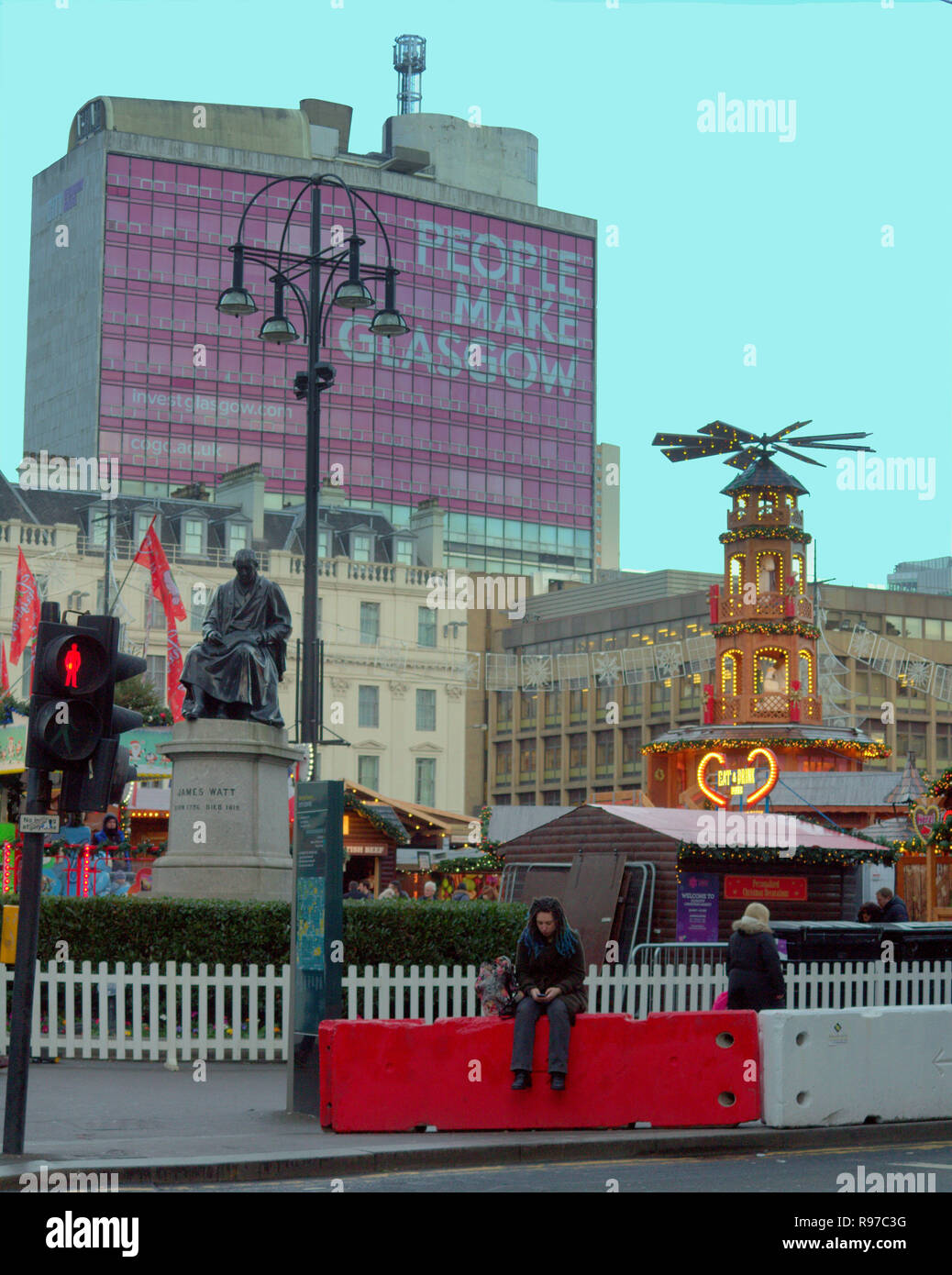 Le persone fanno Glasgow tourist sul telefono seduta per Glasgow il Natale e il nuovo anno in fiera a George Square Foto Stock