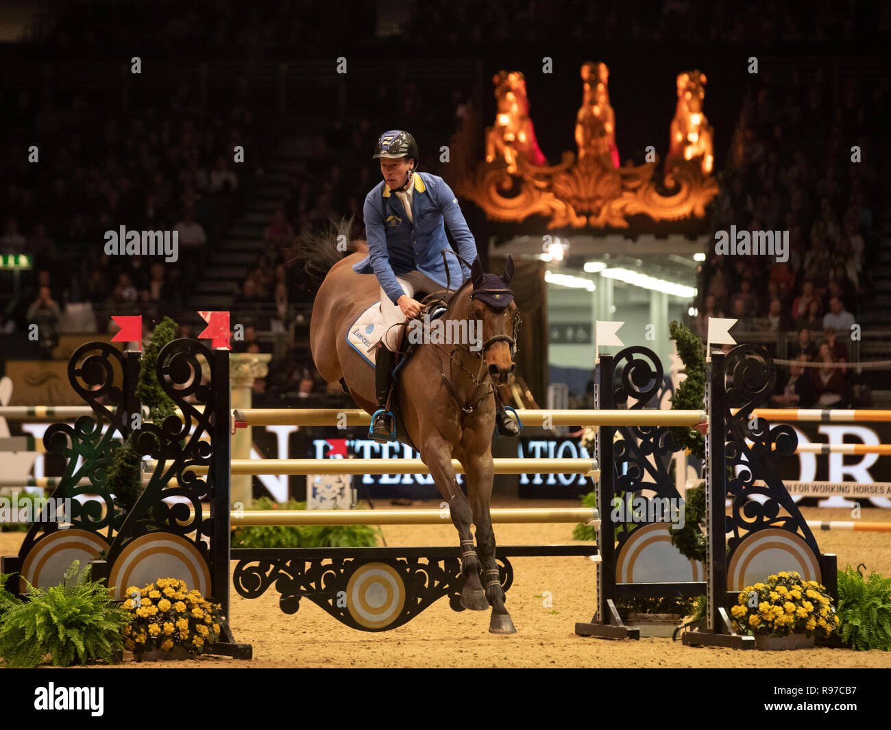 Repubblica federale di Germania Christian Ahlmann equitazione Z atomica si misurano con il simbolo del fiocco di neve picchetti durante il giorno quattro del London International Horse Show a Olympia di Londra. Foto Stock