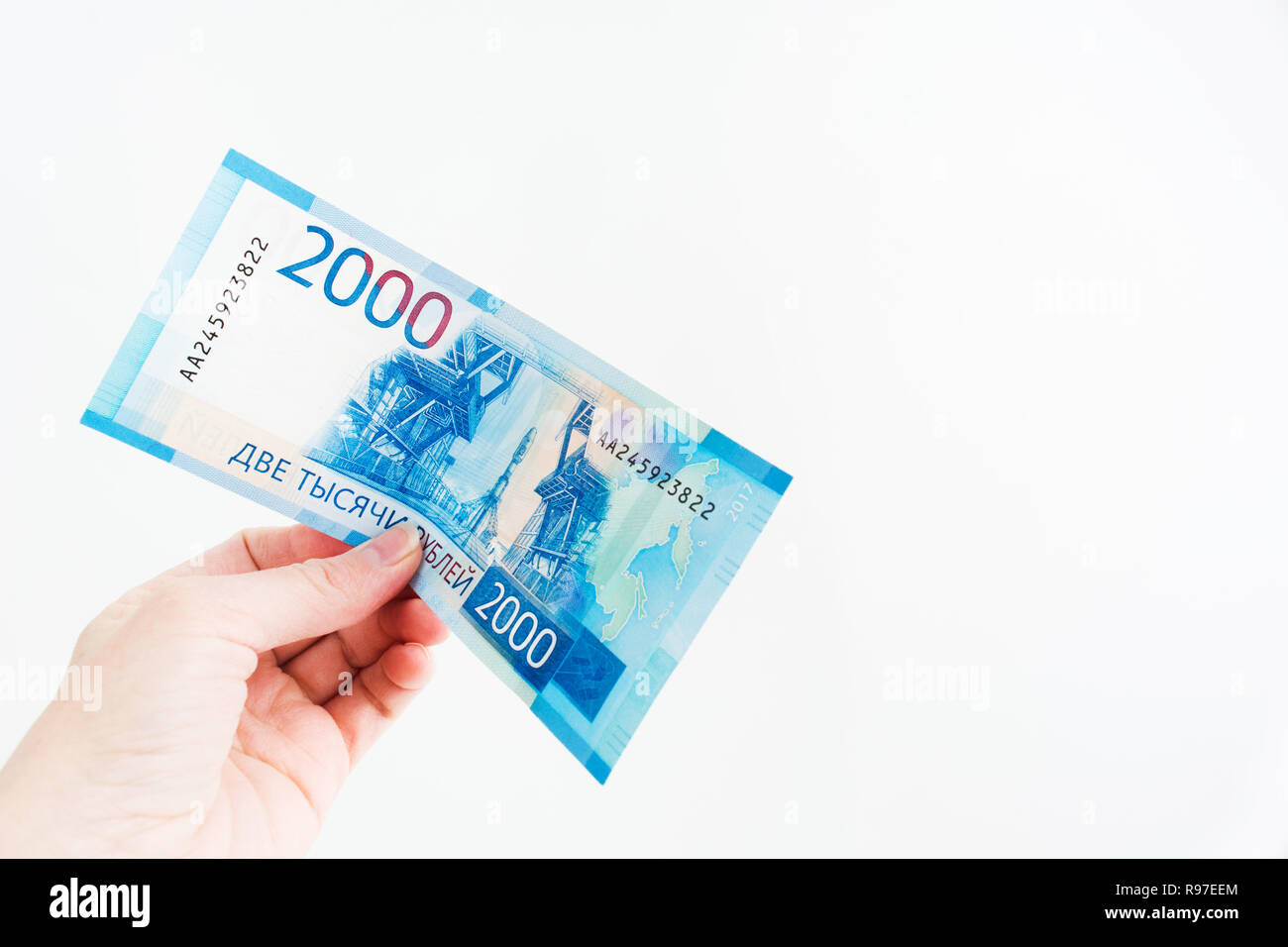 Femmina trattiene a mano 2000 rublo russo bill su sfondo bianco con copia spazio, nuova banconota russo Foto Stock