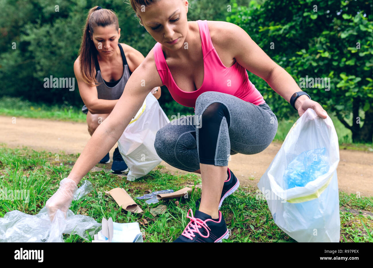 Le donne di prelevare il cestino facendo plogging Foto Stock