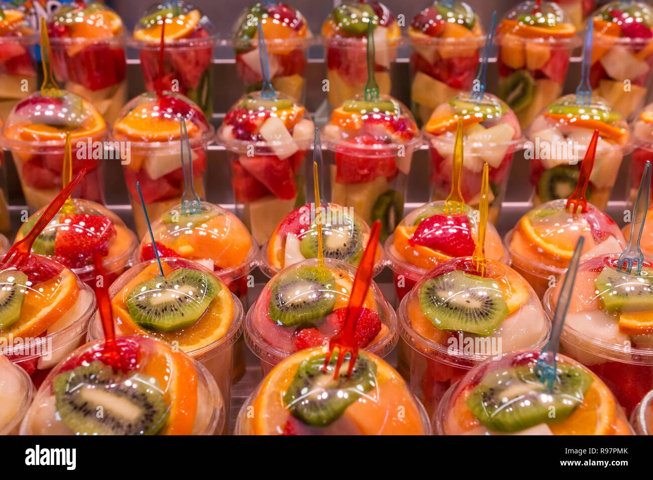 Vari tipi di frutta fresca in bicchieri di plastica per la preparazione di bevande frullato. Fruttato colorati drink e bevande. Foto Stock