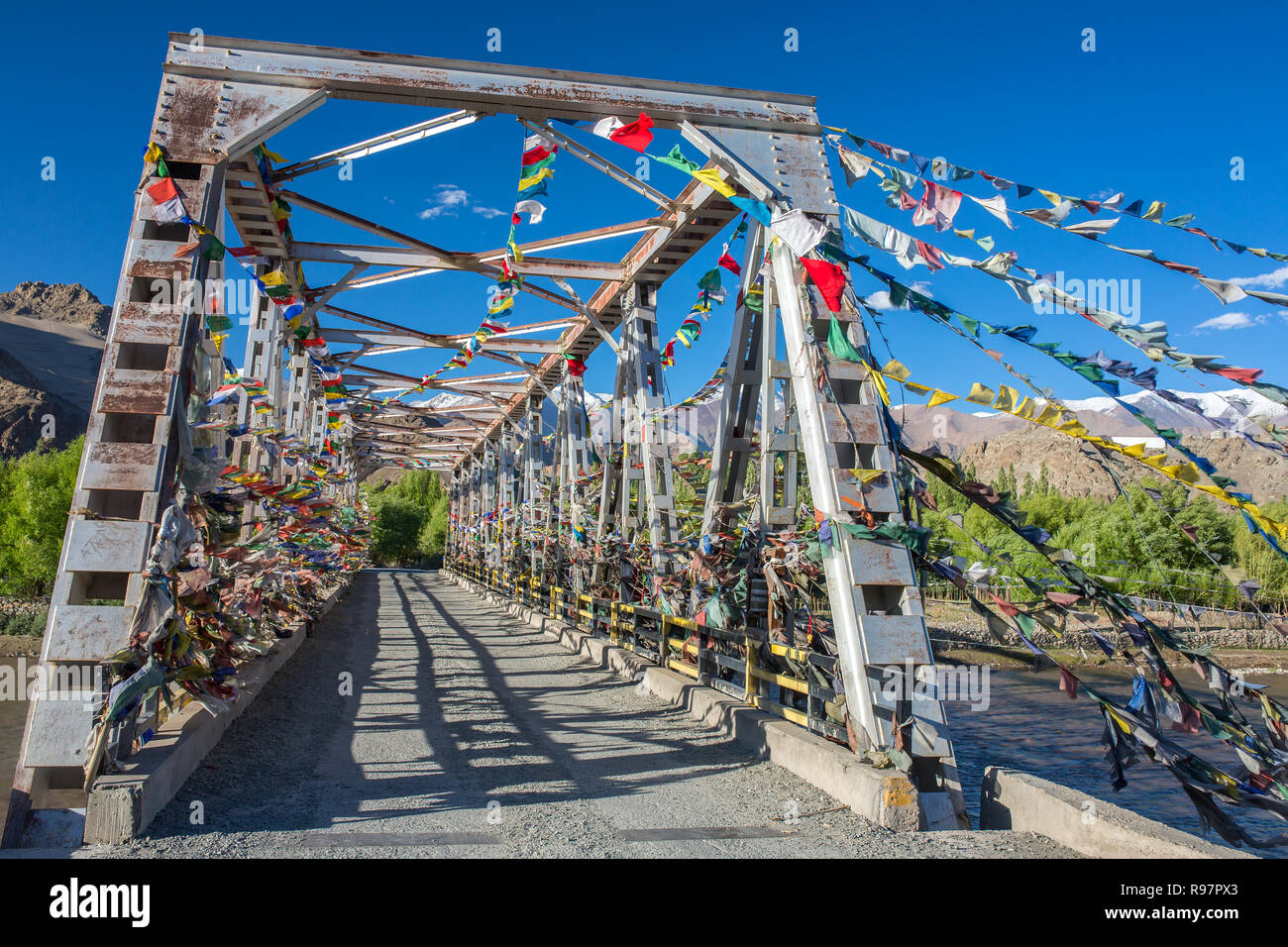 La preghiera buddista bandiere proteggere un ponte sopra il fiume Inuds in Ladakh, India Foto Stock