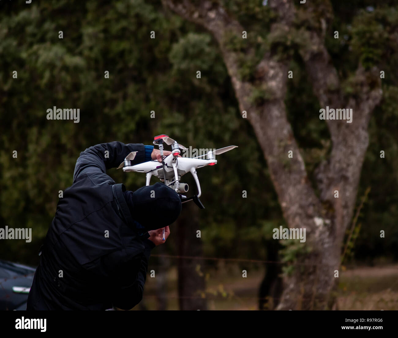 Un drone pilota configurando il suo drone nella foresta prima di volare Foto Stock